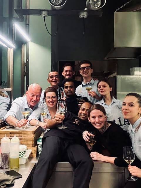 La squadra di Madama Piola in cucina con i calici alzati